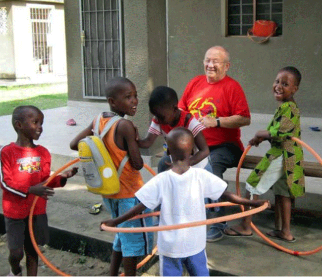 Don Ennio mentre gioca con i bambini